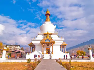Motard sur Royal Enfield serpentant les routes sinueuses entre Paro et Thimphu, avec vallée en arrière-plan