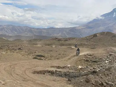 Découverte des paysages lunaires de Mustang – Voyage à moto vers Tsarang, un village avec ses monastères anciens et ses gorges profondes.