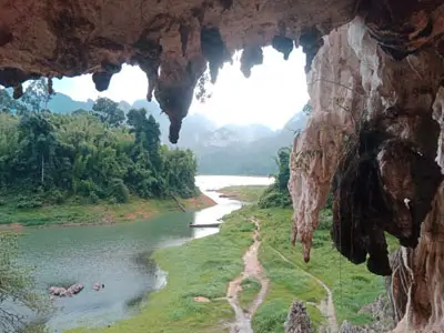 Peaceful exploration of Cheow Lan Lake by traditional boat, framed by majestic karst cliffs and pristine nature