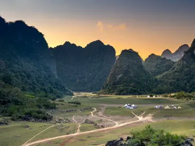 Voyage en Royal Enfield vers les chutes d'eau de Ban Gioc à Cao Bang et les grottes de Nguom Ngao, mettant en valeur les merveilles naturelles du Vietnam.